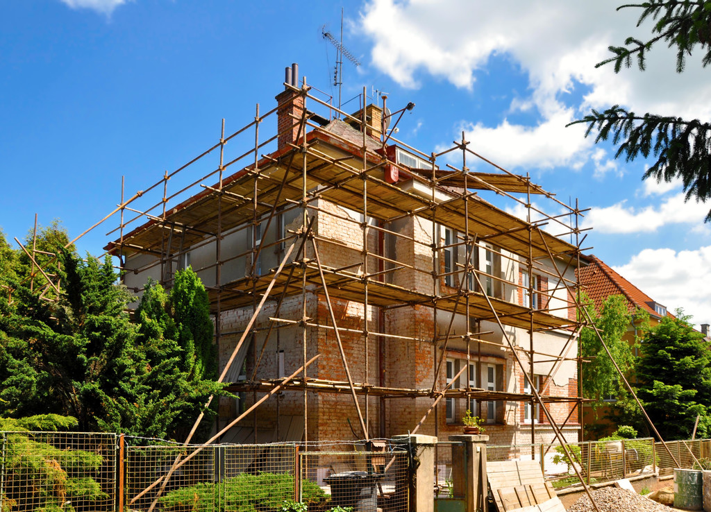 Heavy duty steel frame scaffolding system with orange safety barriers, showing robust construction materials with proper spacing and structural integrity