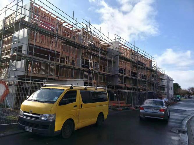 Suspended swing stage scaffolding system with orange safety cables, showing hanging platform for facade work and exterior maintenance